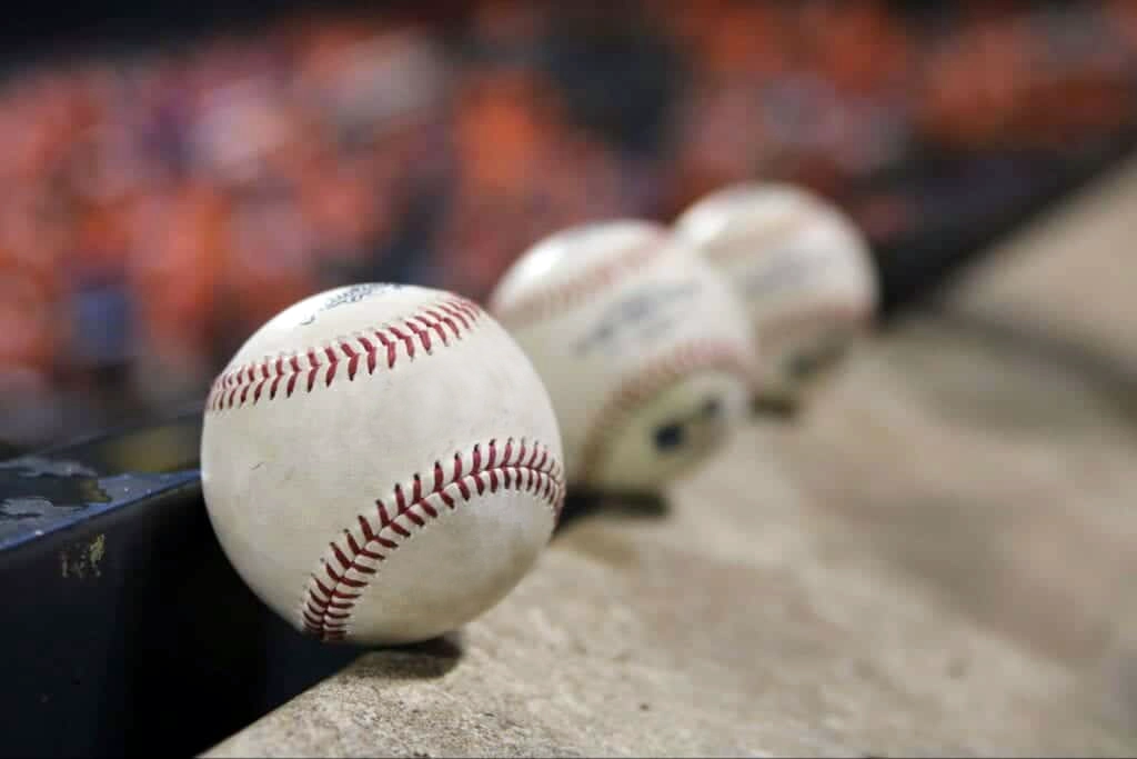 Baseballs in front of fans with MLB tickets